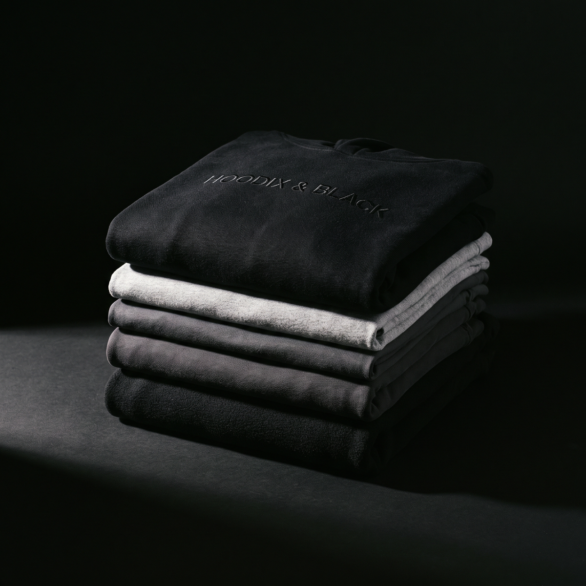 HOODIX & BLACK — pile de sweats et t-shirts pliés, marque brodée ton sur ton